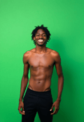 Joyful Skinny Man with Curly Hair in Green Setting
